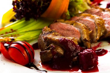 Fırında ördek sebze ve otlar stüdyo ışık beyaz bir tabakta yemek