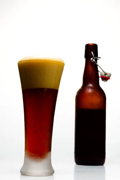 Σκοτεινή μπύρα σε ένα ποτήρι και ένα μπουκάλι μπύρα σε λευκό φόντο — Φωτογραφία Αρχείου