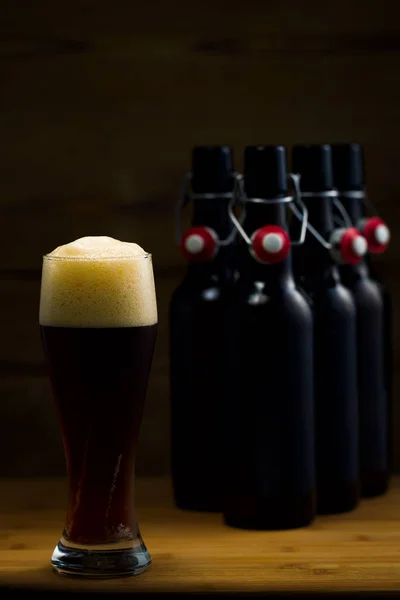 Vasos de cerveza y botellas de cerveza sobre un fondo de madera — Foto de Stock