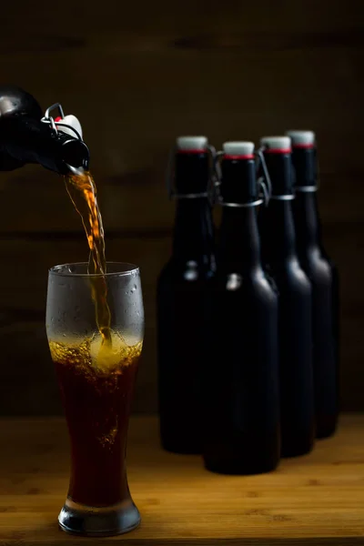 Copos de cerveja e garrafas de cerveja em um fundo de madeira — Fotografia de Stock