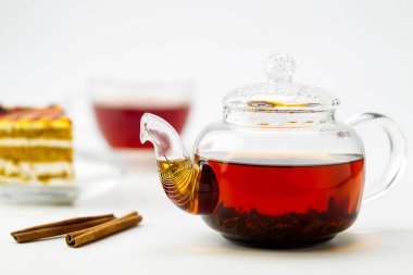 Çaydanlık, çay bardağı ve beyaz zemin üzerine pasta