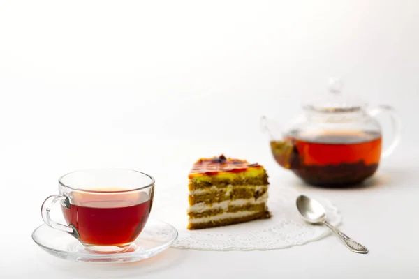 Bule, xícara de chá e bolo no fundo branco — Fotografia de Stock