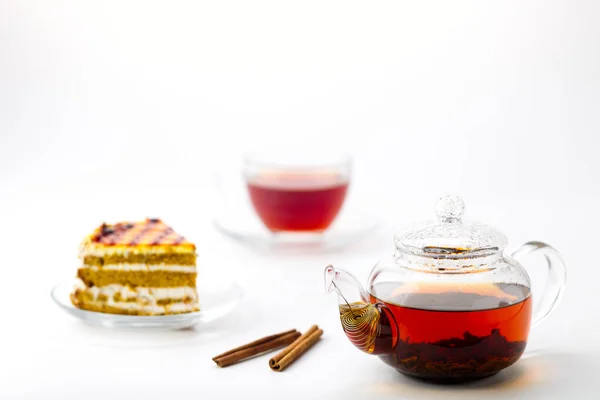 Bule, xícara de chá e bolo no fundo branco — Fotografia de Stock