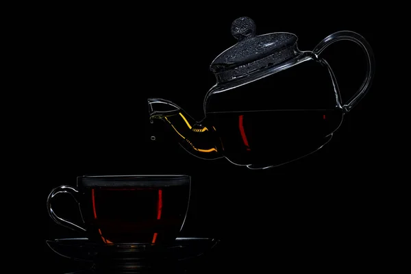 Théière transparente avec thé noir sur fond noir — Photo