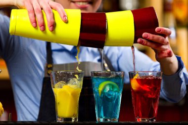 Barmen barda kokteyl hazırlıyor.