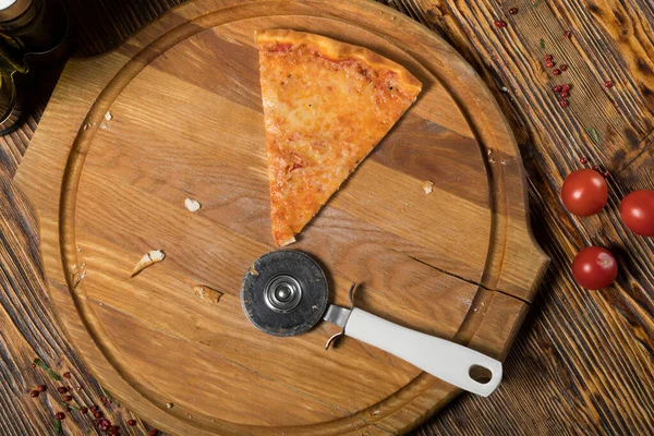 ピザのスライス 木製のトレイのピザナイフ トマト チーズ 木製のテーブルの上のガラスデカンタのオリーブオイル — ストック写真