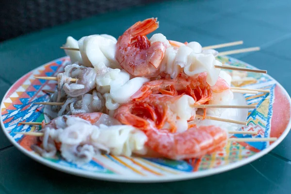 Seafood kebab on a plate. Shrimp, squid, octopus. Healthy food. Evening with friends. Gifts of the sea.