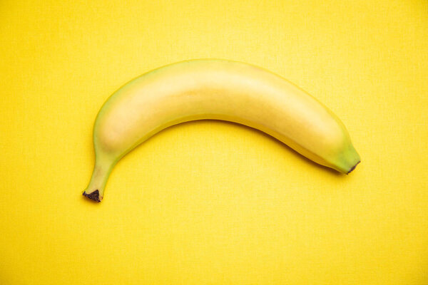 Single banana yellow background