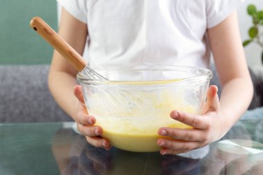 Elleriyle waffle hamuru tutan bir çocuğun üst gövdesine yakın çekim. Un, yumurta, süt ve şekerle lezzetli bir hamur çırp. Hamur pişmeye hazır. Çocuk aşçısı.. 
