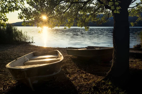 Una hermosa puesta de sol en el lago de Pusiano con dos barcos de la fila doc — Foto de Stock