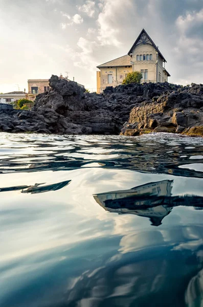 Denizin üzerinde günbatımında, Catani yansıyan güzel lüks evler