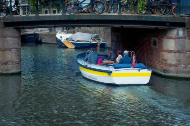 Küçük kanal tekne geçen bir köprünün altında Amsterdam, Hollanda