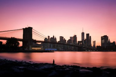 Arka planda New York silueti olan Brooklyn Köprüsü, günbatımında çekilen