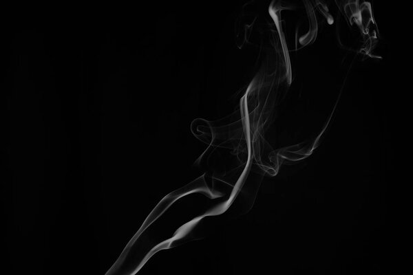 A whisp of white smoke against the black background