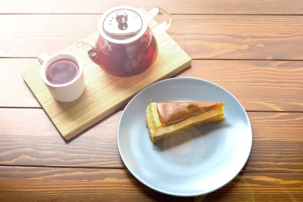 Chaleira com chá de frutas vermelhas e cheesecake de chocolate — Fotografia de Stock