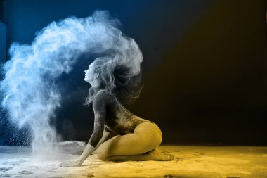 Beyaz toz bulutu içinde dans eden ince sarışın.