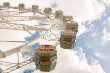 Mavi gökyüzü, bulutlar ve arka planda güneş ışığı olan bir tekerlek parçası.