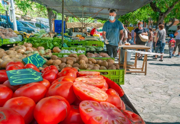 Sineu, Balearic Adaları / İspanya; Mayıs / 20 / 2020: Sineu 'deki geleneksel sokak pazarında meyve ve sebze tezgahı. Covid-19 'un yeni sosyal önlemleri için eldiven ve maskeli satıcı ve alıcılar