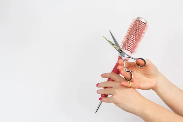 Ножиці і рожева щітка для волосся на руці жінки — стокове фото