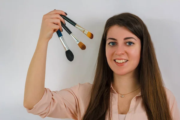 Chica artista de maquillaje con cepillos en las manos —  Fotos de Stock