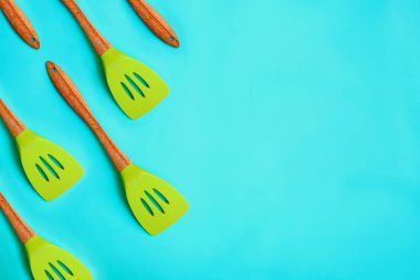 Mavi arka planda yeşil mutfak spatulası deseni