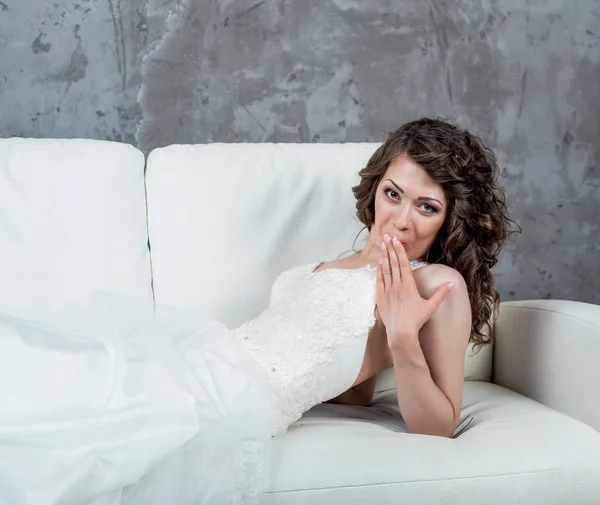 Junge Frau lächelt im Hochzeitskleid-Studio — Stockfoto