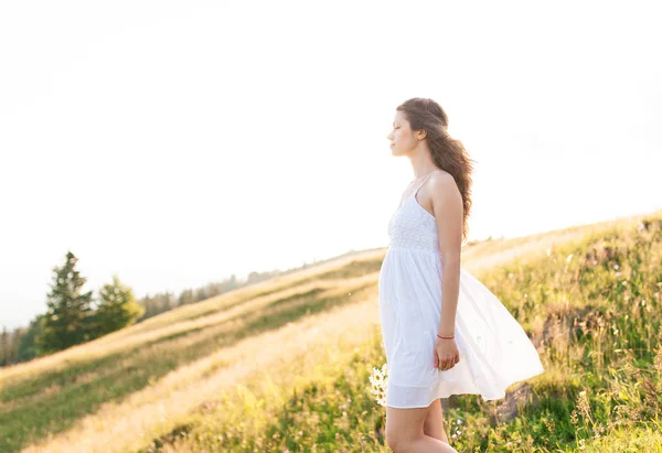 Молодая женщина с длинными волосами смотрит на горный пейзаж — стоковое фото