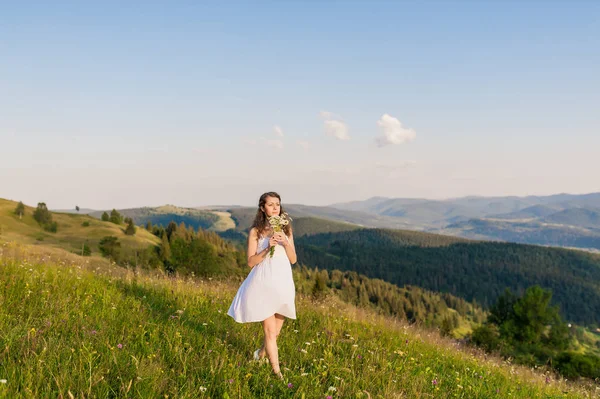 Jeune femme aux cheveux longs regardant un paysage de montagne — Photo