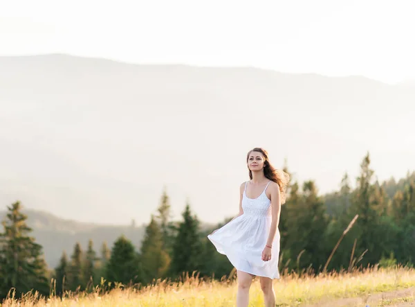 Junge Frau mit langen Haaren blickt auf eine Berglandschaft — Stockfoto