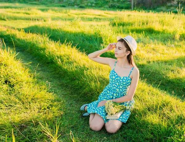 Молодая романтичная девушка читает книгу сидя на траве — стоковое фото