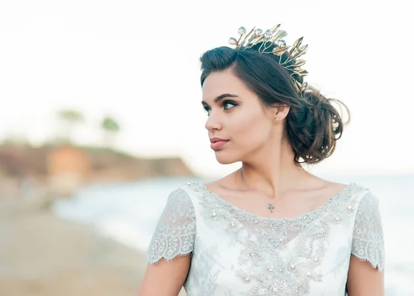 Romantic beautiful bride in luxury dress posing on the beach.