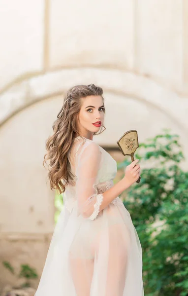 Ritratto di giovane sposa in boudoir di pizzo bianco con capelli scuri ondulati — Foto Stock