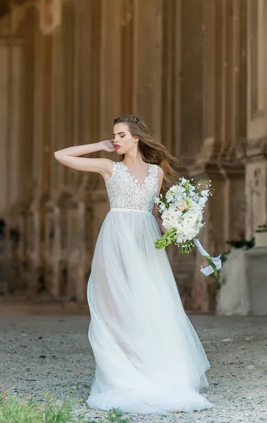 Romantische mooie bruid in luxe jurk poseren van prachtige architectuur — Stockfoto