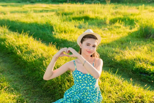 Menina bonita fazendo mãos em forma de coração ao ar livre — Fotografia de Stock