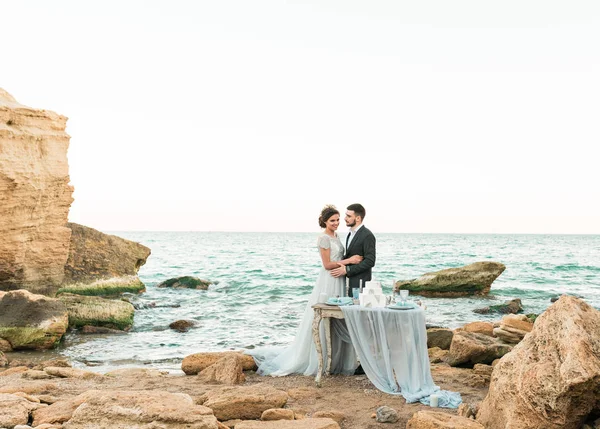 Casamento casal, noivo e noiva em vestido de noiva perto do mar à beira-mar — Fotografia de Stock