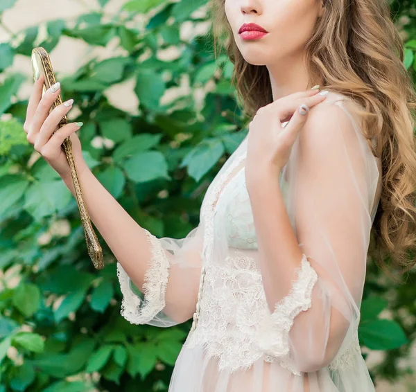 Dalgalı siyah saçlı beyaz dantelli bir gelinin portresi.