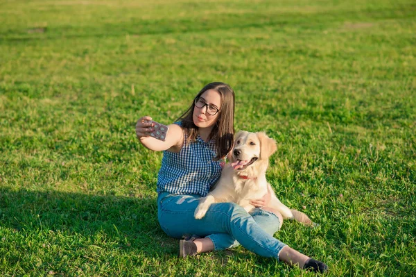 genç kadın ve bir selfie bir parkta alarak onun dostu köpek