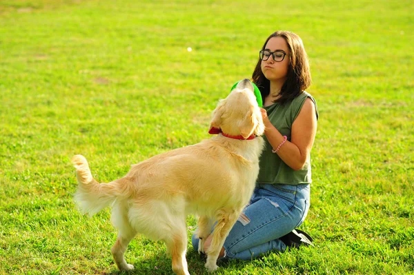 Jeune femme jouant avec son chien au parc — Photo