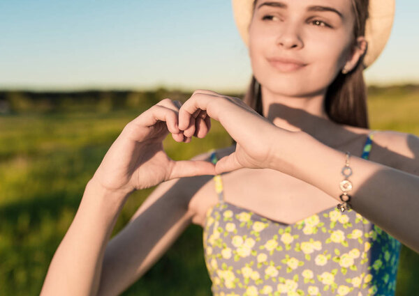Pretty girl making hands in heart shape outdoors — Stock Photo, Image