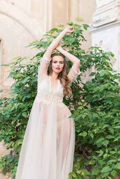 Ritratto di giovane sposa in boudoir di pizzo bianco con capelli scuri ondulati — Foto Stock