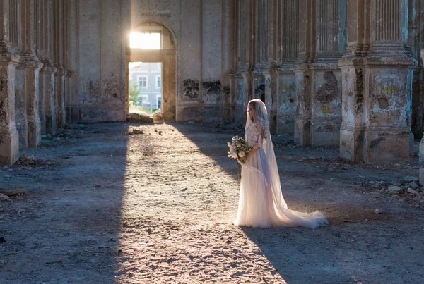 Mooie bruid vrouw in elegante witte kanten jurk met bruiloft boeket — Stockfoto