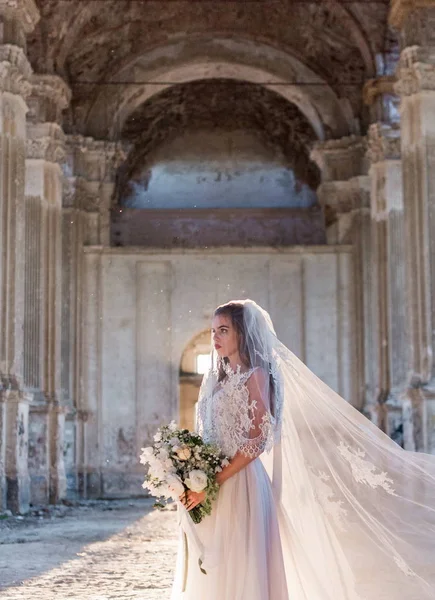 Romantic beautiful bride in luxury dress posing of beautiful architecture — Stock Photo, Image