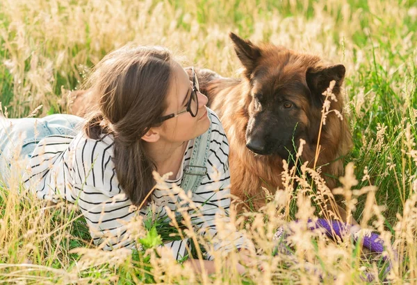 Mladá žena a její přátelský pes v parku — Stock fotografie