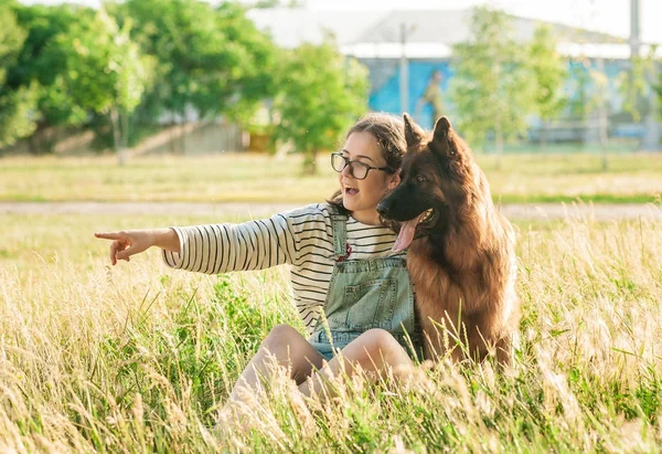 Vrouw knuffel haar hond Duitse herder in herfst park — Stockfoto