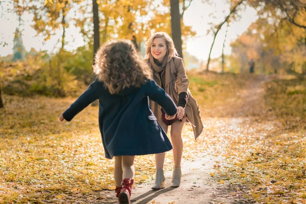 Щаслива молода сім'я розважається в осінньому парку — стокове фото