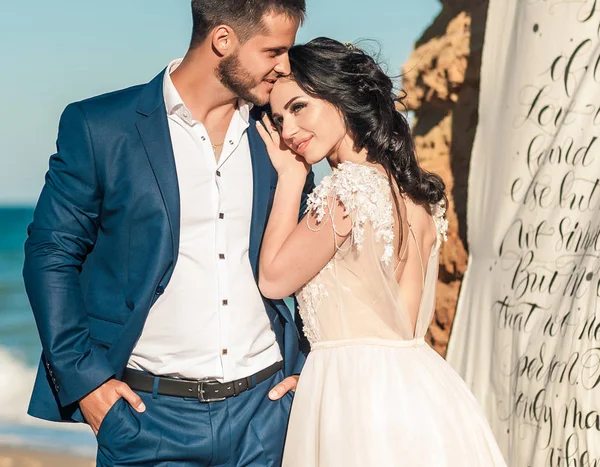 Düğün çifti, gelin ve damat deniz kenarında gelinlik giymişler.