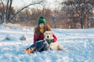 Genç güzel kadın kucaklama golden retriever köpek karda