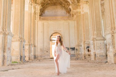 Dalgalı siyah saçlı beyaz dantelli bir gelinin portresi.