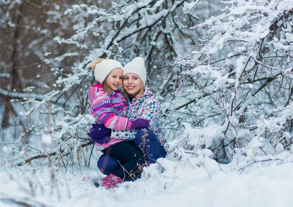 Familia joven abrazando y riendo en invierno nevado paseo en la naturaleza . — Foto de Stock