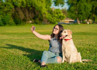 genç kadın ve bir selfie bir parkta alarak onun dostu köpek